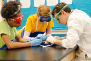 Students wearing goggles working on science project in a lab